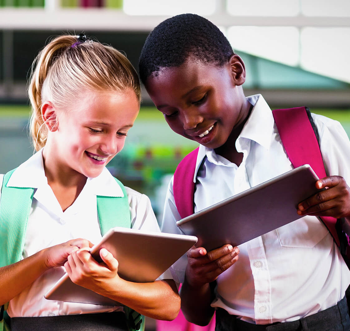 School kids using digital tablet in school cafeter.