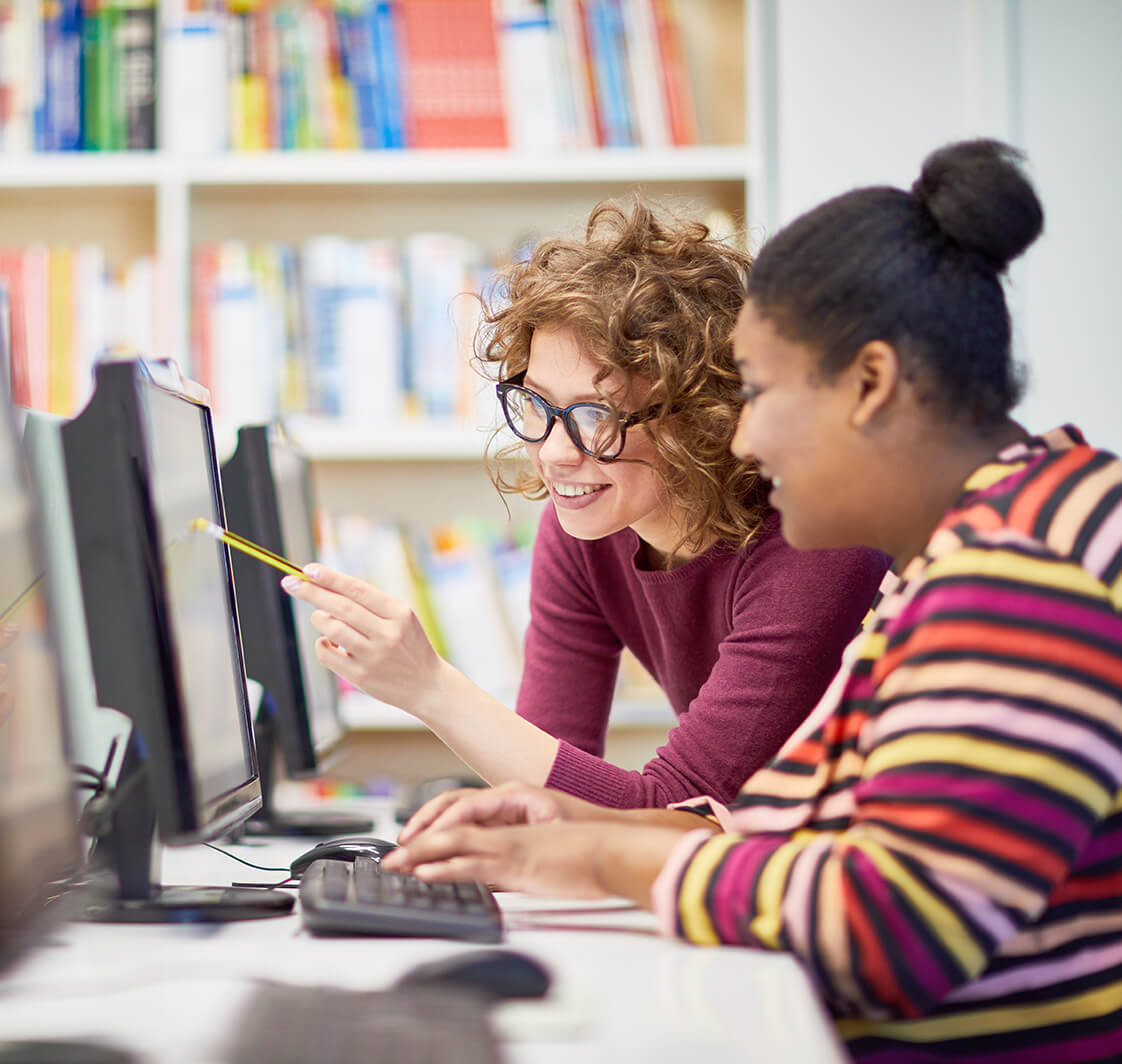 Teacher and student looking at a computer.