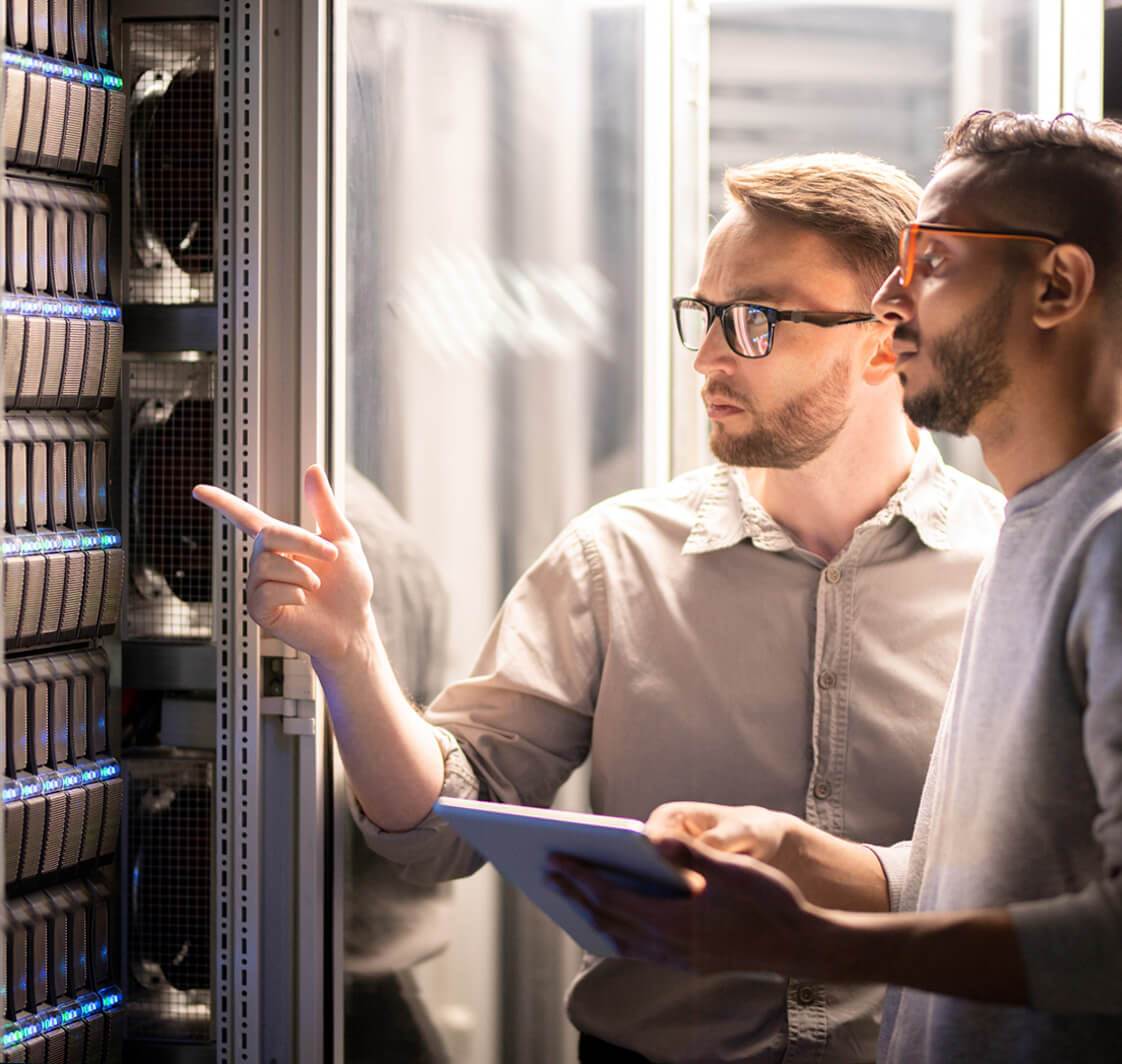 Two IT Technicians working in a server room.