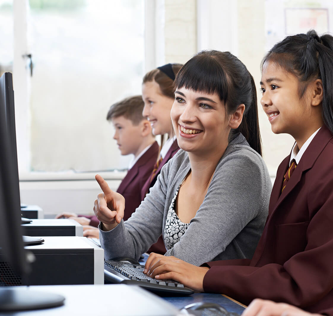 Teacher showing pupil something on a computer.