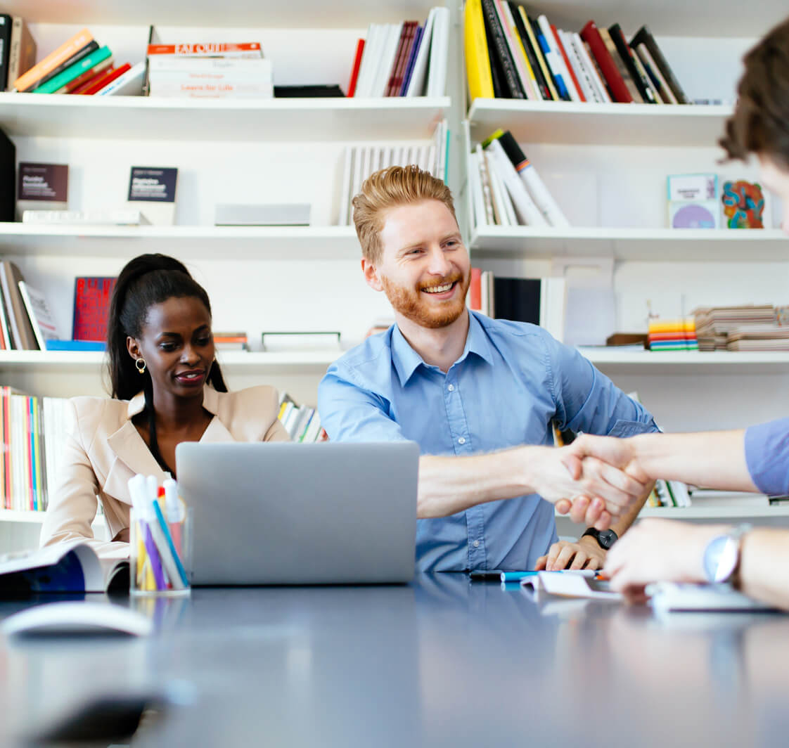Teachers in a room shaking hands.