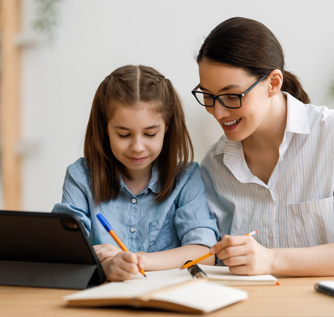 child working at home with parent on a portable device.