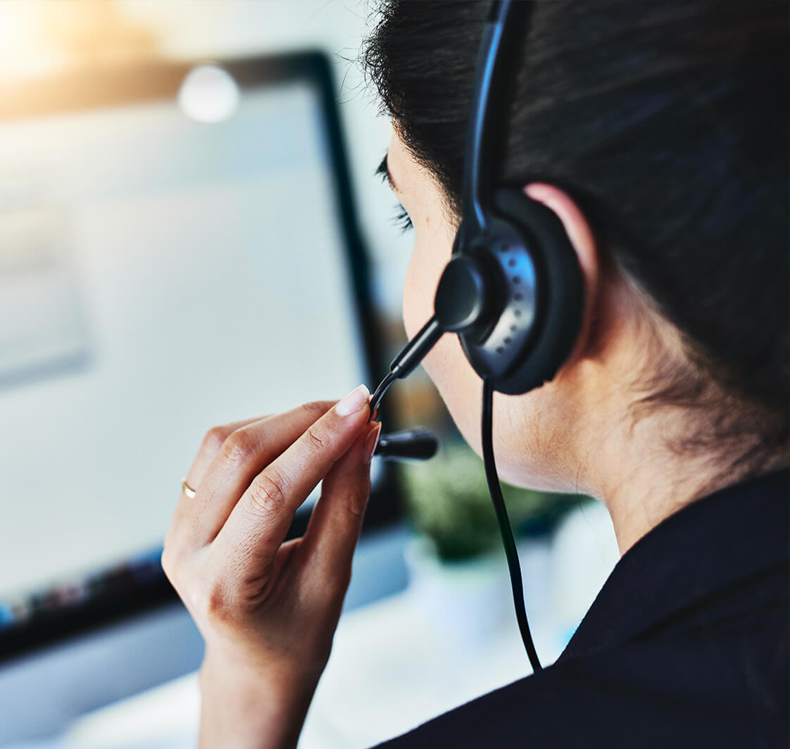 Woman making a call on a headset in an office.