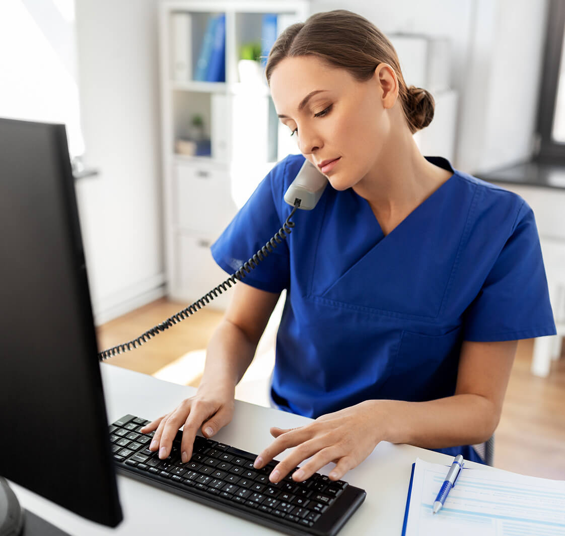 Medicine, technology and healthcare concept - female doctor or nurse with computer calling on phone at hospital.