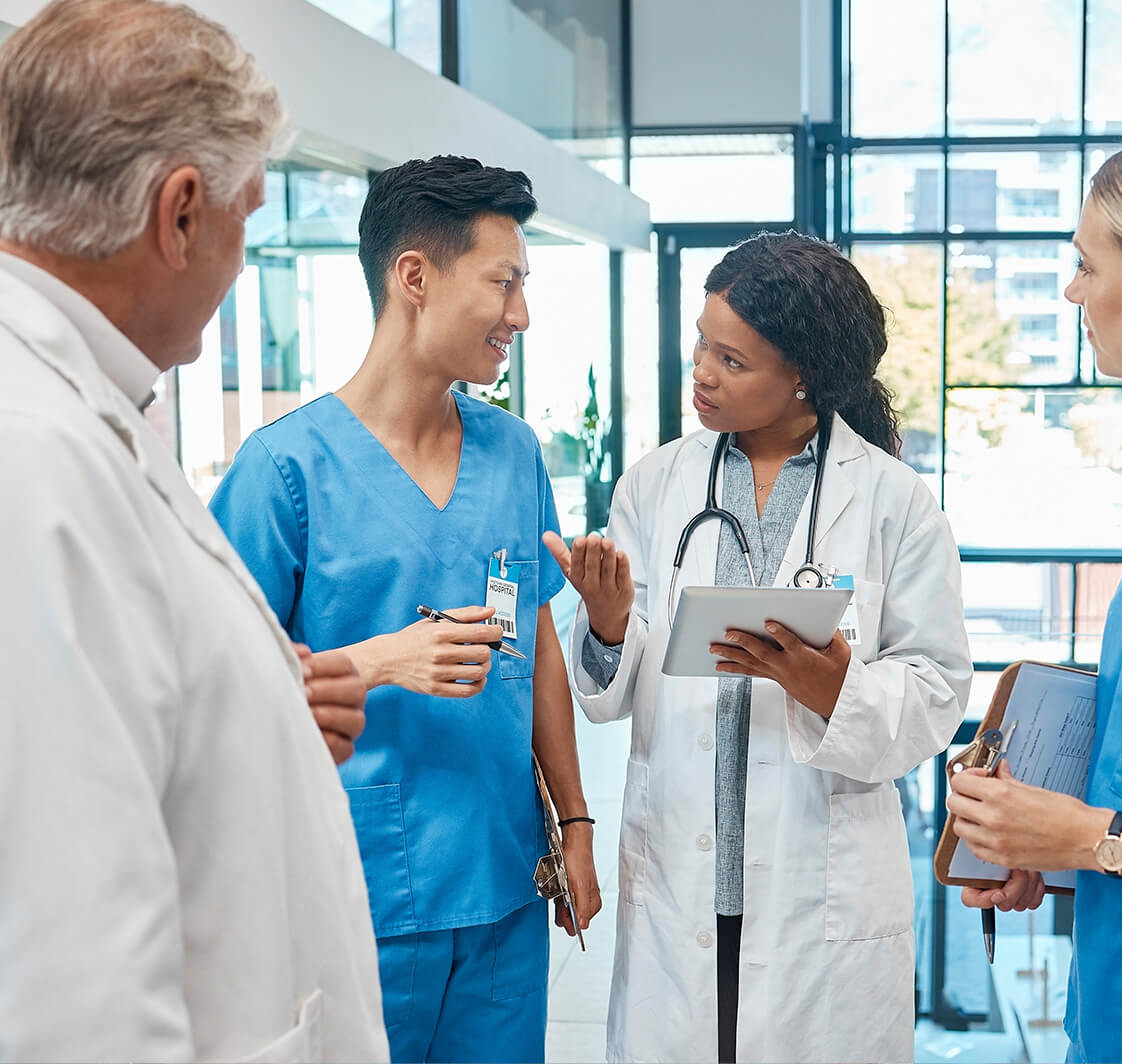 Healthcare, doctors and nurses talking in a hospital with a tablet for research, planning or schedule. 