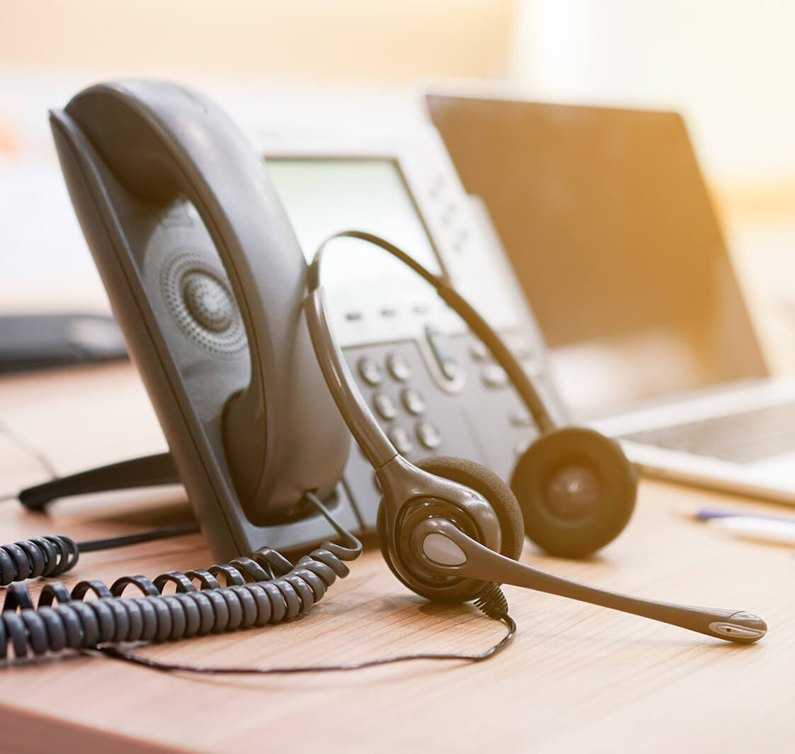 close up soft focus on headset with telephone devices at office desk for customer service support concept