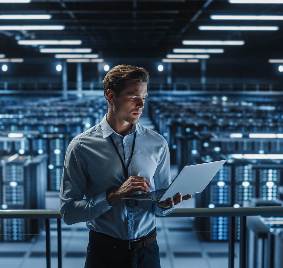 Portrait of IT Specialist Uses Laptop in Data Center.