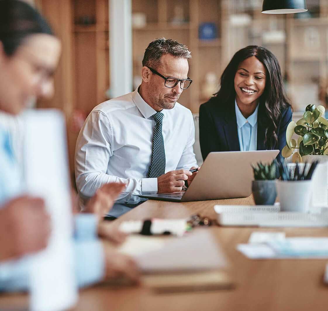 Two business people looking at a laptop.