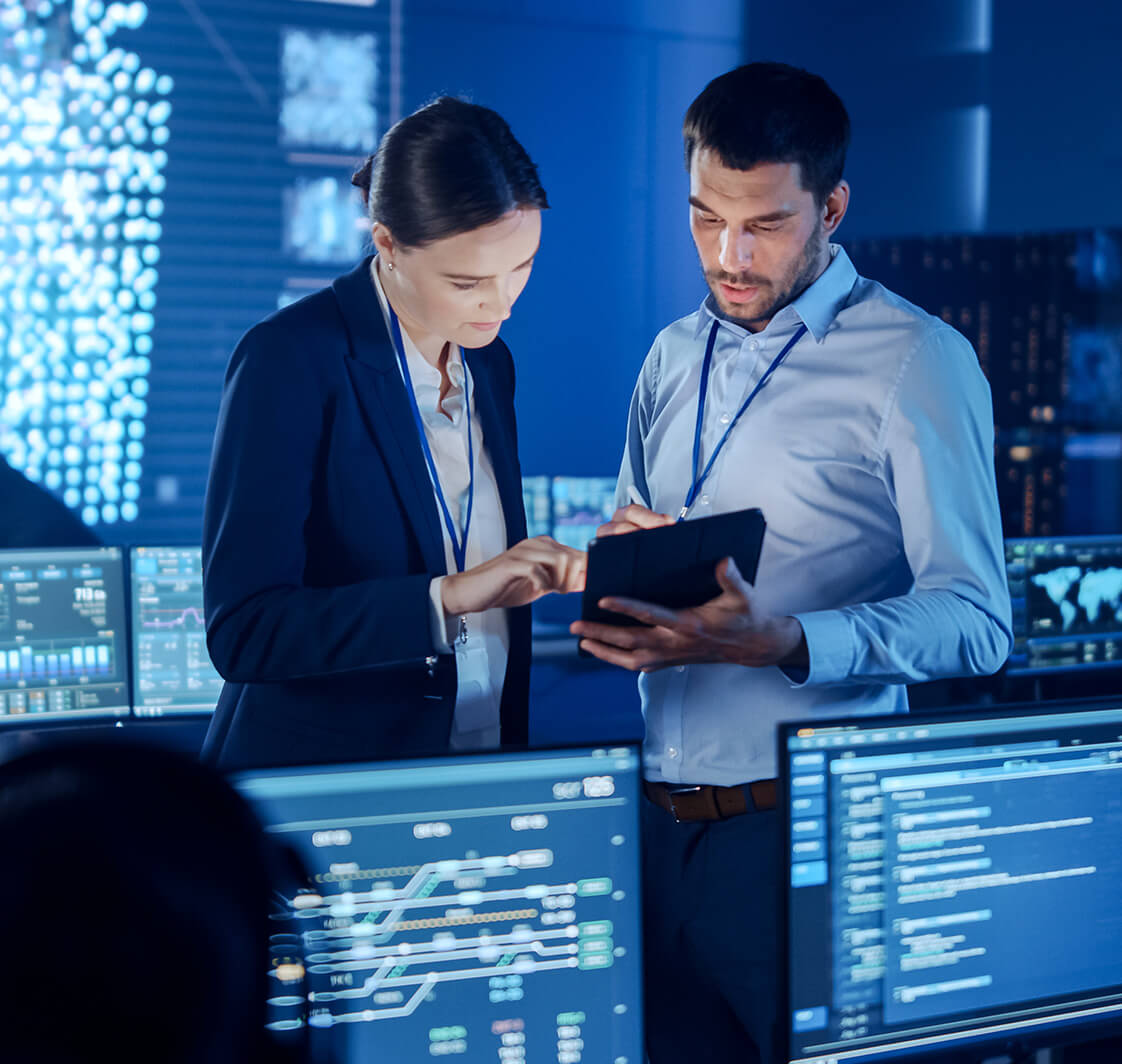 Project Manager and Computer Science Engineer Talking while Using A Digital Tablet Computer. Telecommunications Company System Control and Monitoring Office Room with Working Specialists.