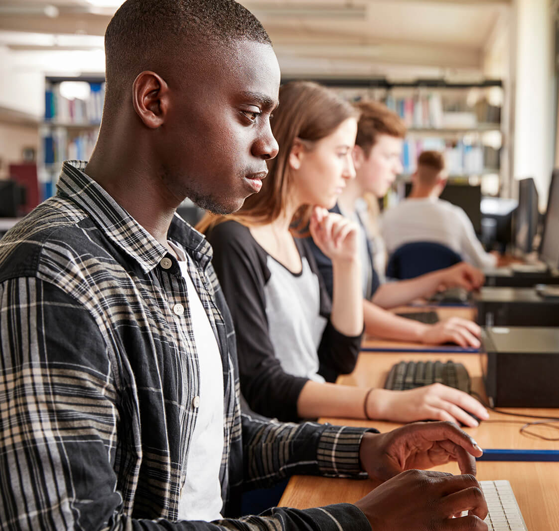 Group Of Students Using Computers In College Library.