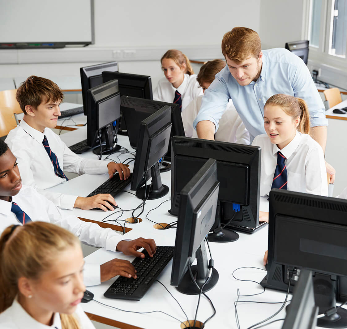 Teenage Students Wearing Uniform Studying In IT Class.