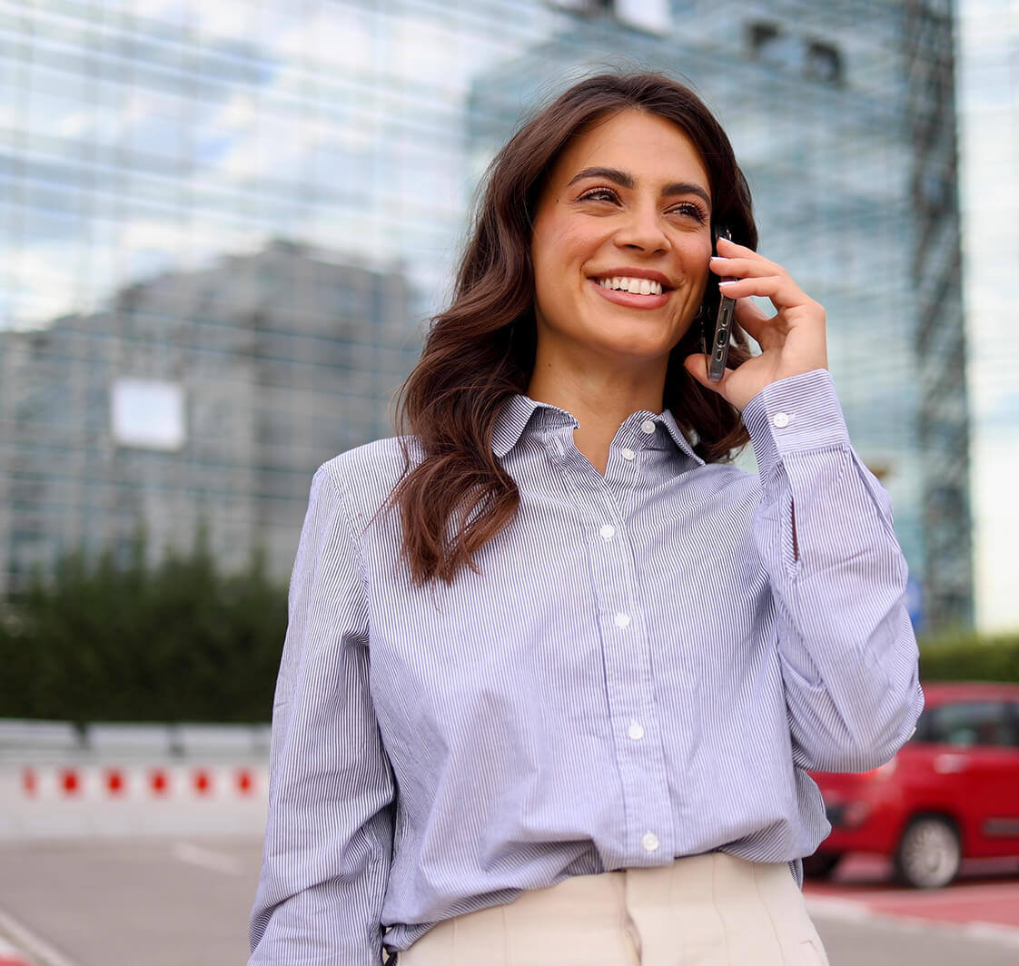 Young businesswoman talking on mobile phone and enjoying in the city.