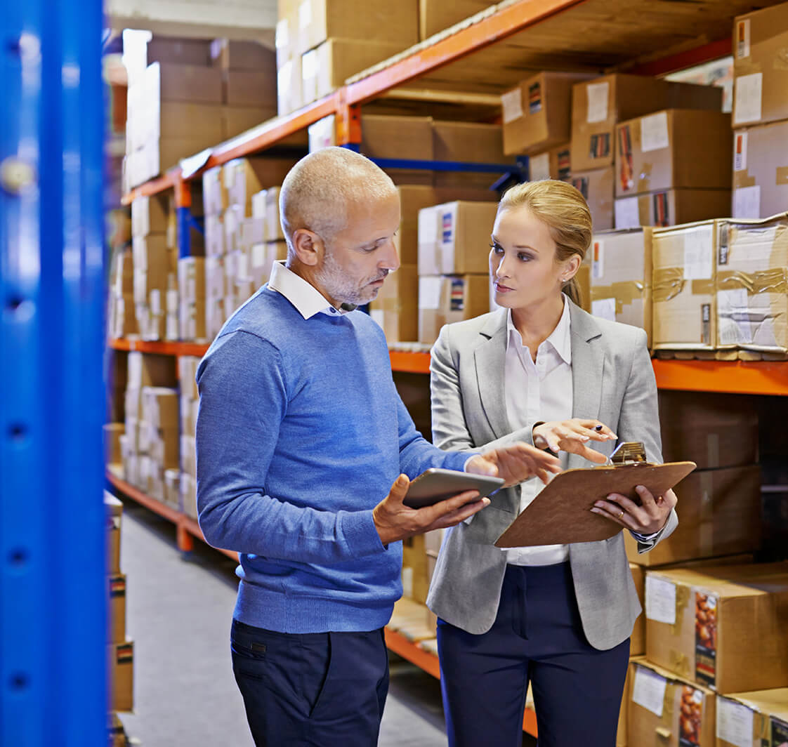 Shot of a man and woman inspecting inventory in a large distribution warehouse.