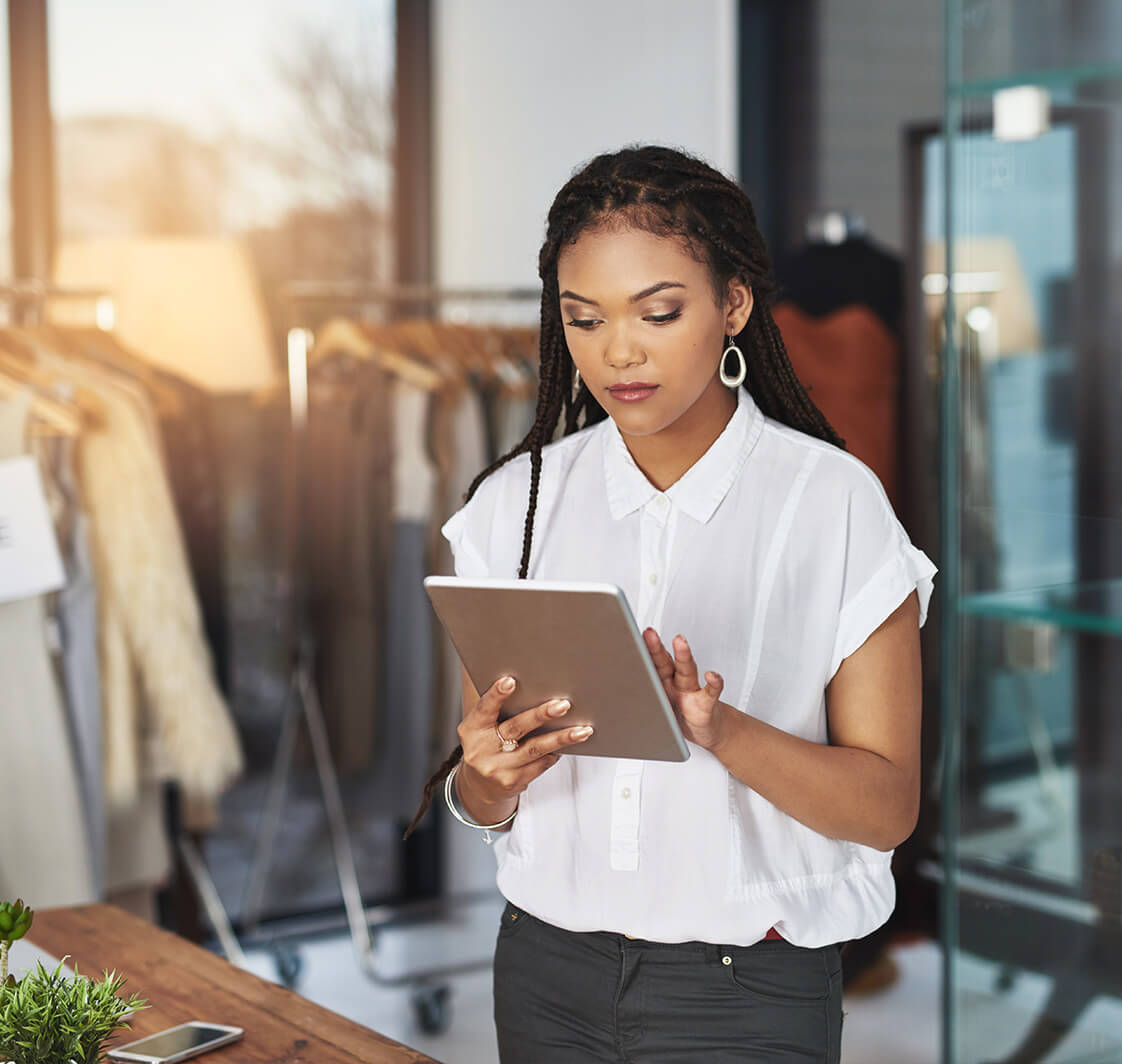 Cropped shot of a young business owner using her tablet while standing in her store.