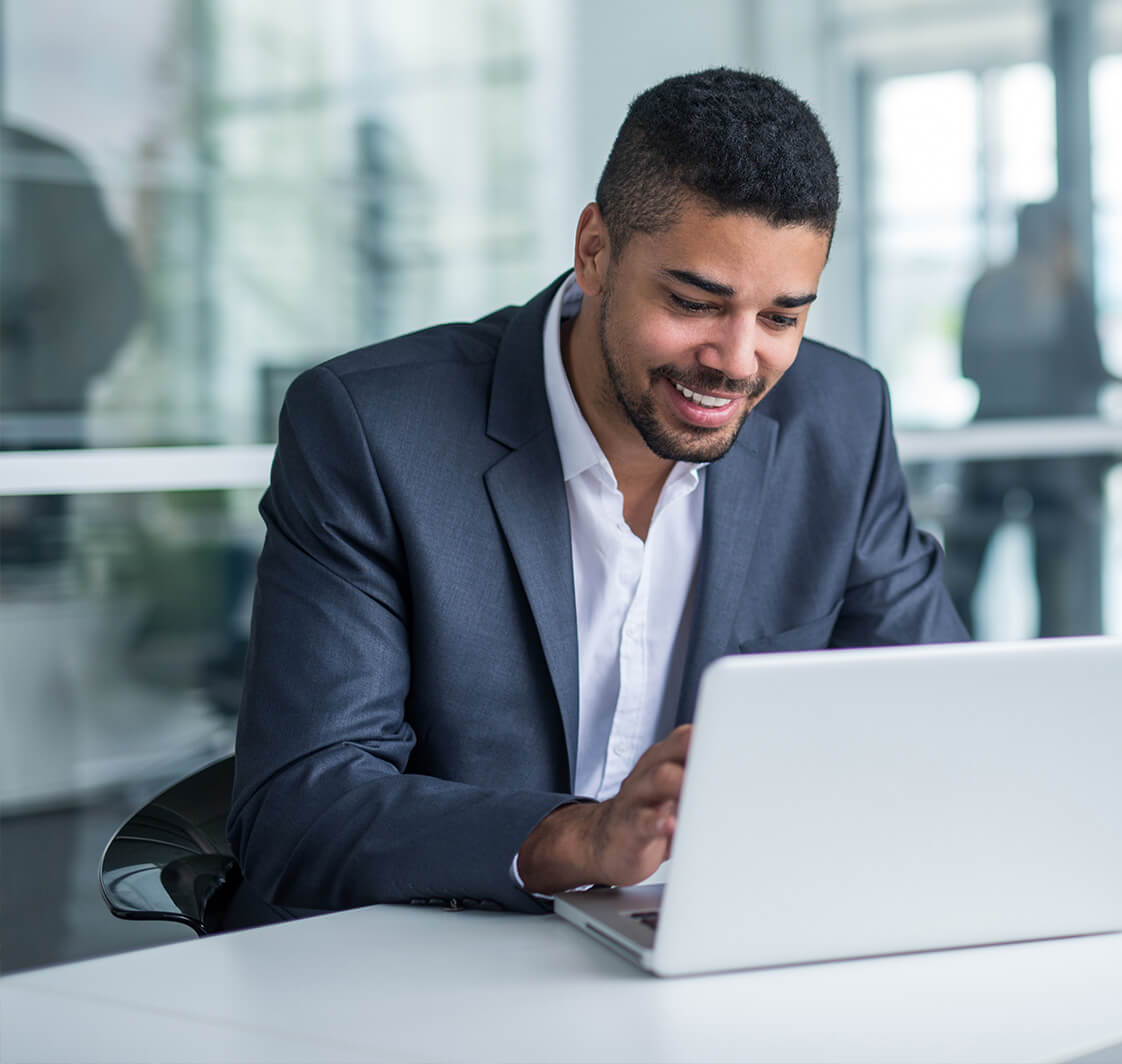 Man working on a computer and smiling.