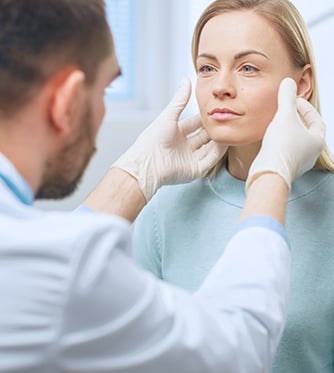 Plastic / Cosmetic Surgeon Examines Beautiful Woman's Face, Touches it with Gloved Hands, Inspecting Healed Face after Plastic Surgery with Amazing Results.