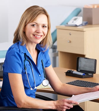 UK doctor sitting at desk