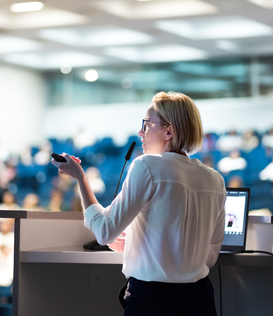 Female Speaker Presenting at a Conference