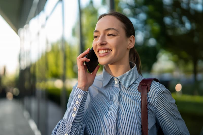 Female field worker smiling on her mobile phone