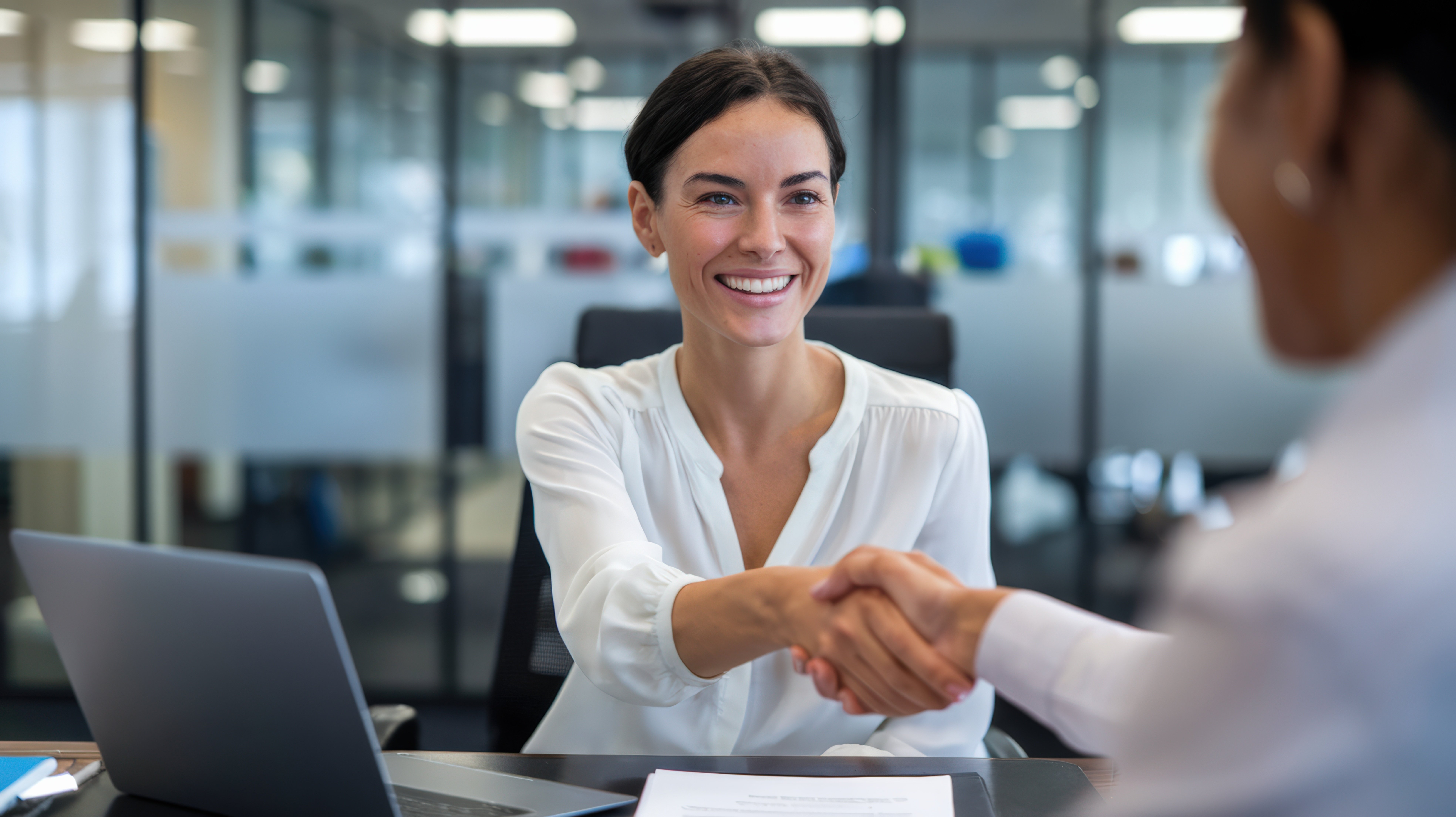 Smiling office worker shaking hands with a customer
