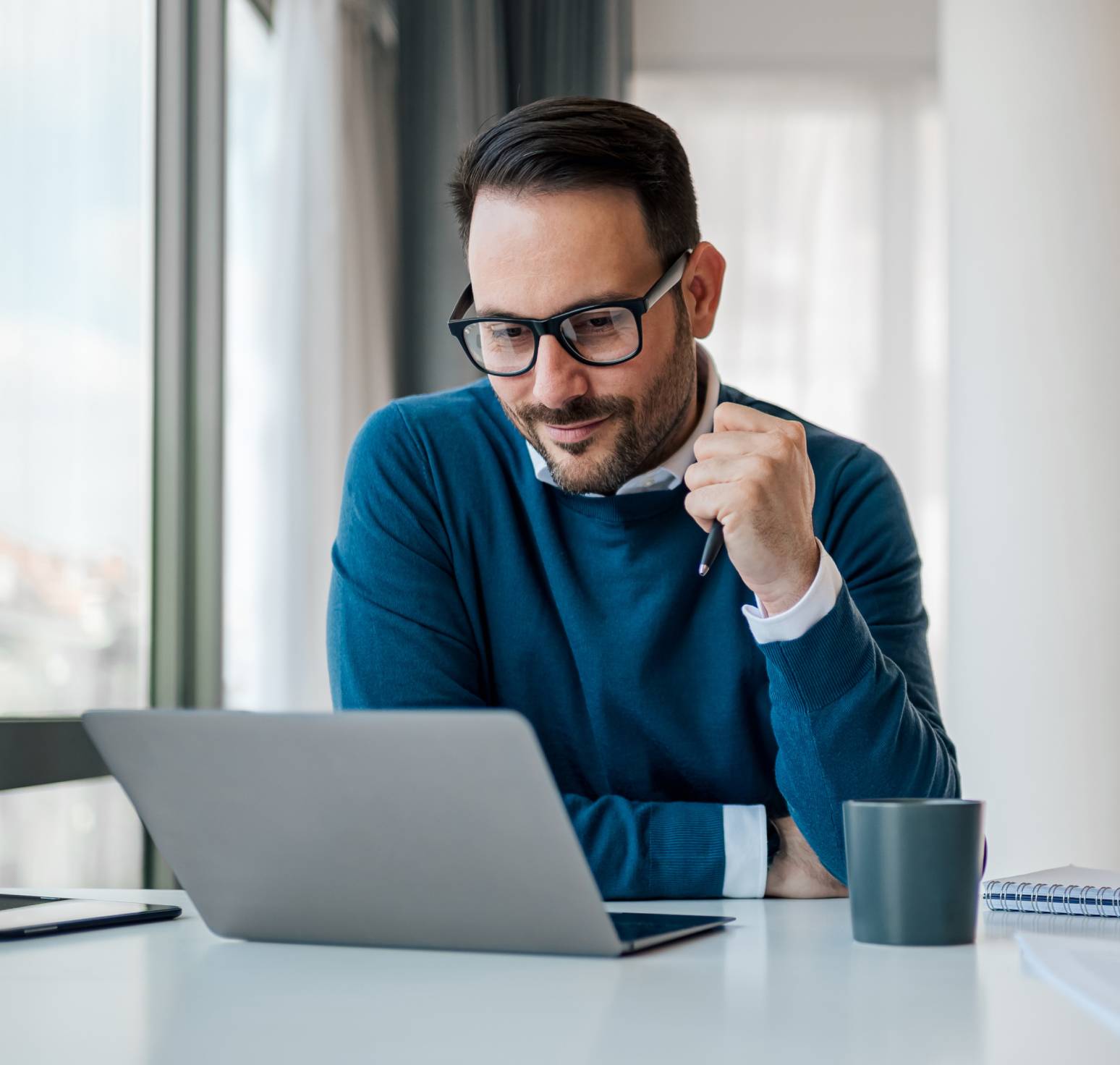 Employee at home on laptop with mug of tea