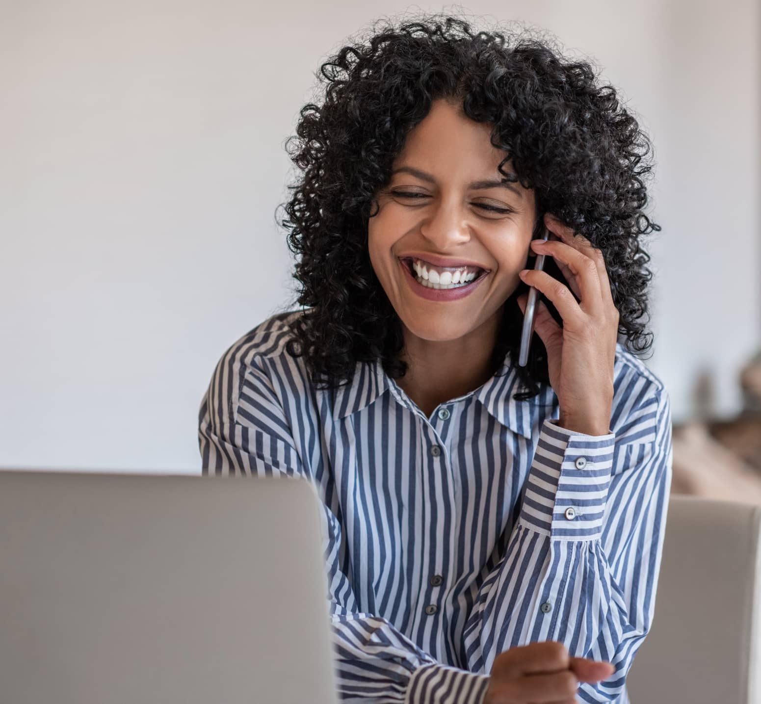 Female worker on mobile in front of laptop