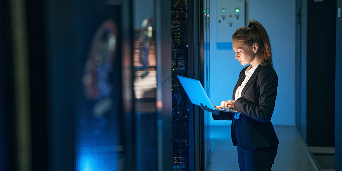 woman checking security details in a server room.