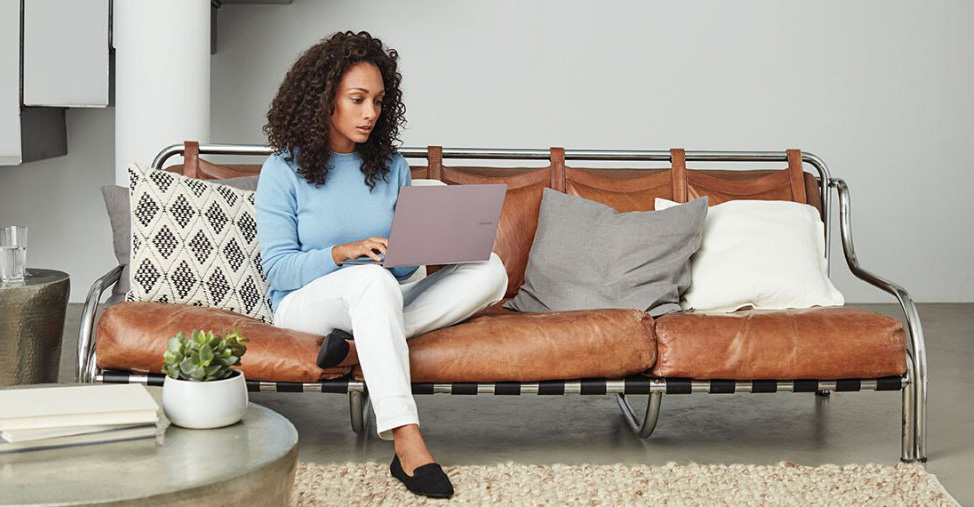 Woman sat on sofa working on a laptop